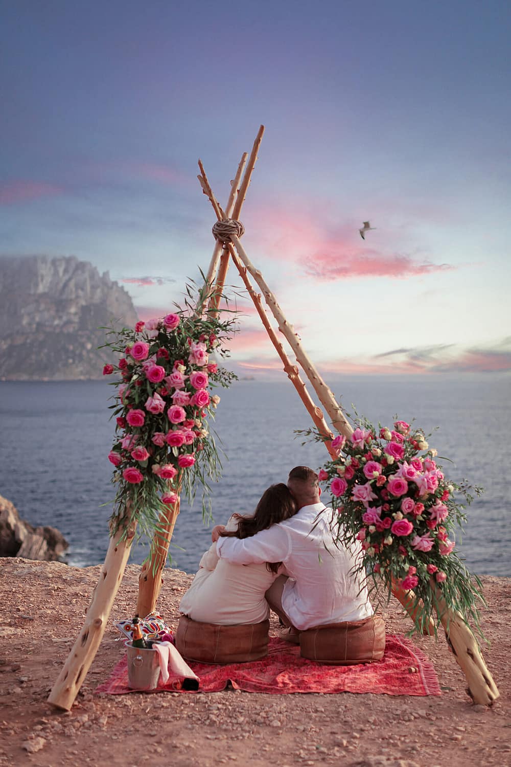photo couple embracing at sunset surrounded by flowers with photographer in ibiza