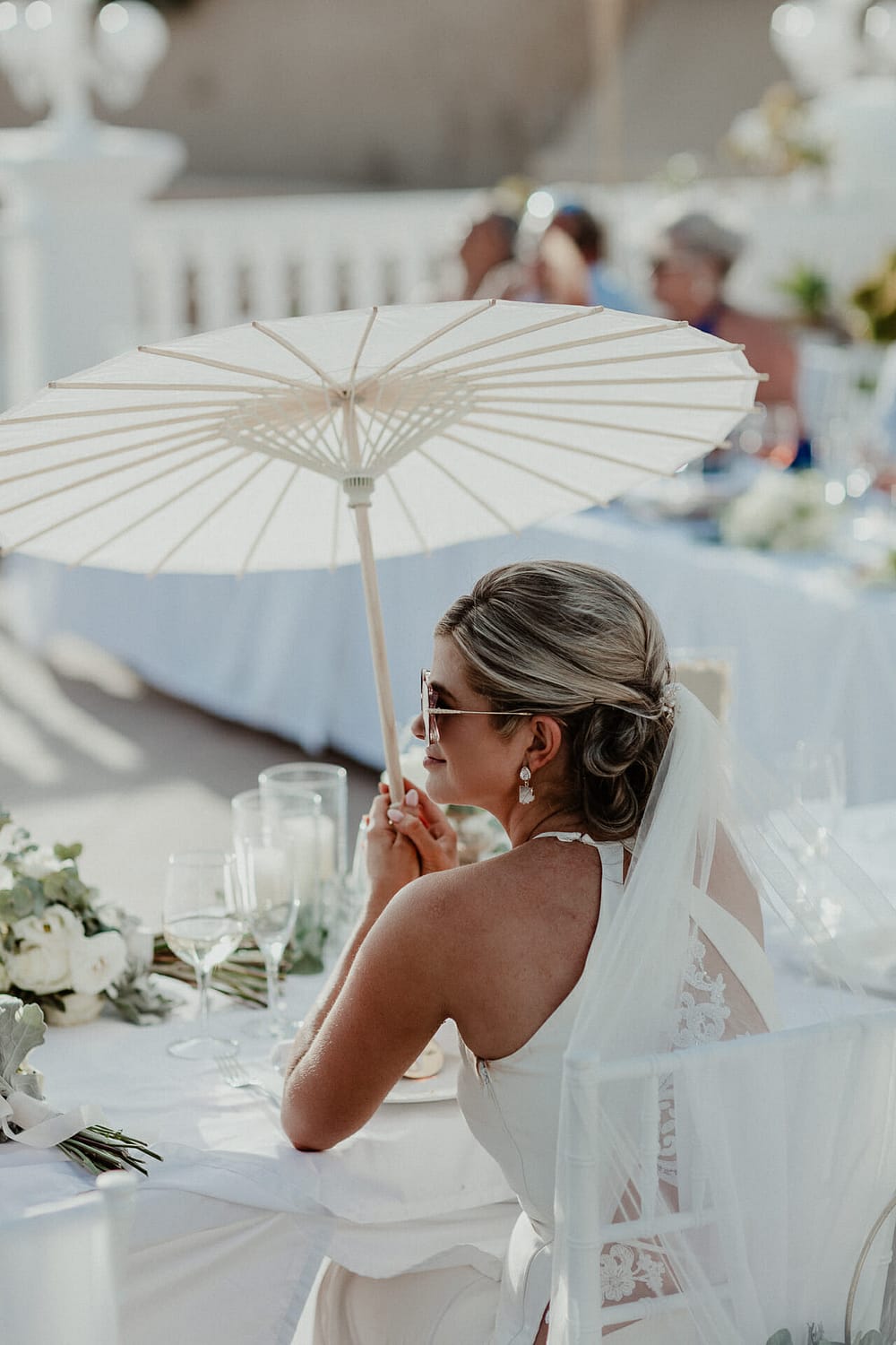 foto de novia con paraguas sentada en terraza