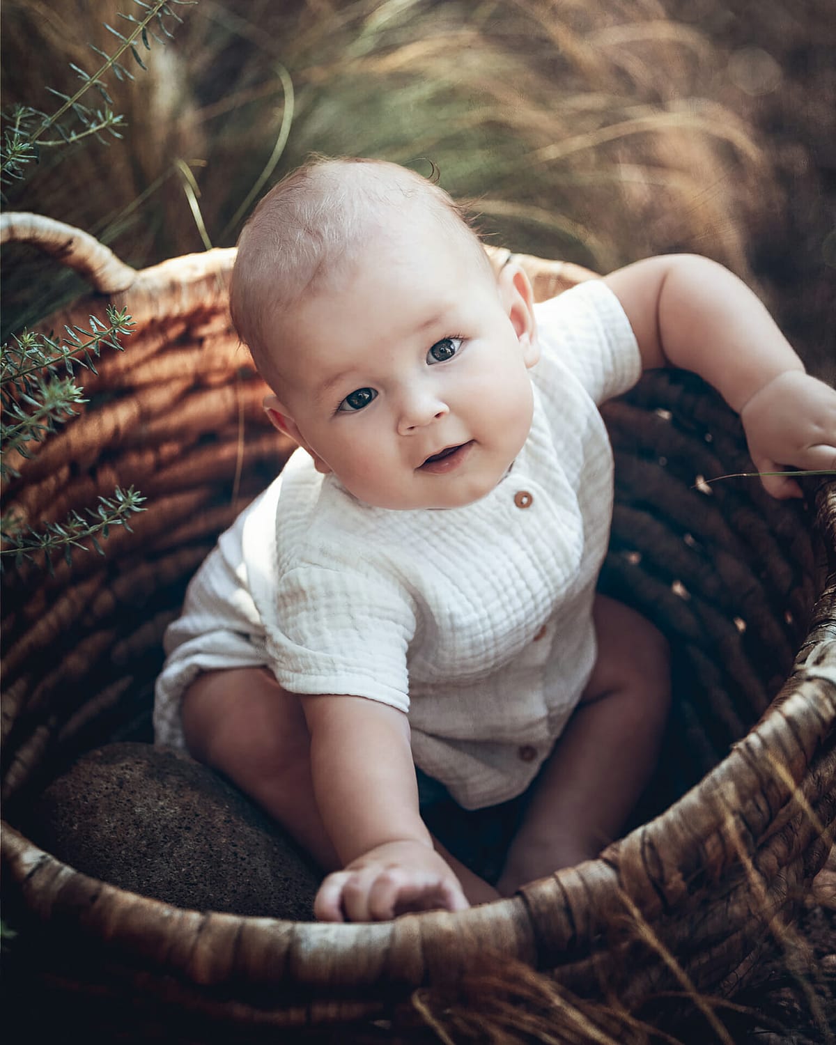 baby photography in a wicker basket with a photographer in ibiza