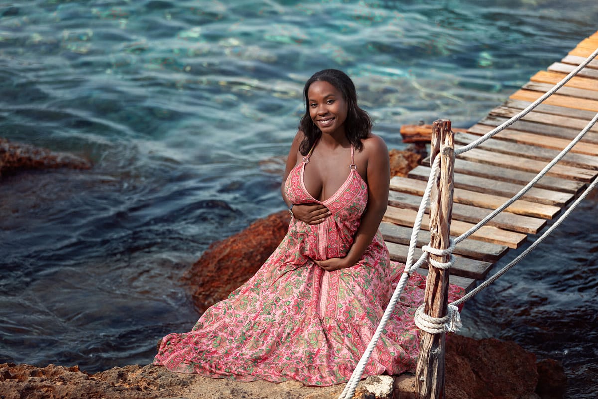 fotografia mujer embarazada posando sentada en la playa fotografo en ibiza
