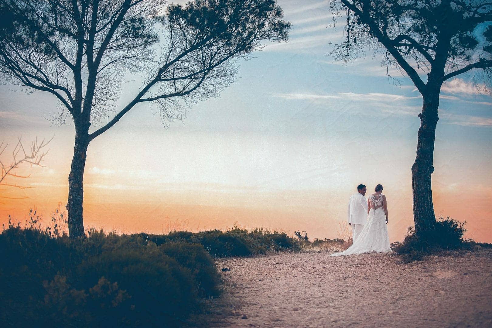 photograph of a couple while they walk on the cliff of one of the beaches of sant miguel at sunset time