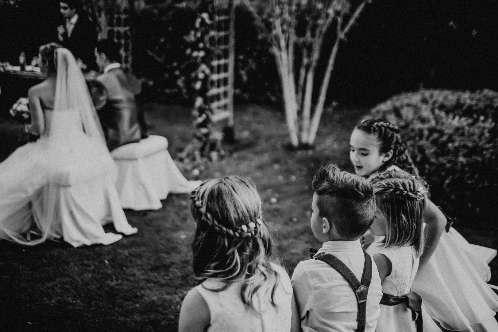 Documented photograph at the time of the ceremony with children and the bride and groom at the altar in the restaurant garden in Ibiza