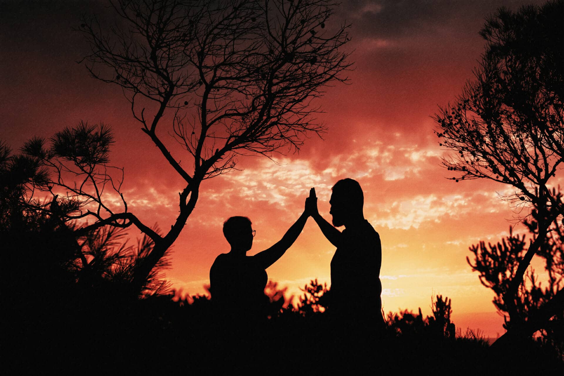 backlit image of couple at sunset posing for photographer in ibiza