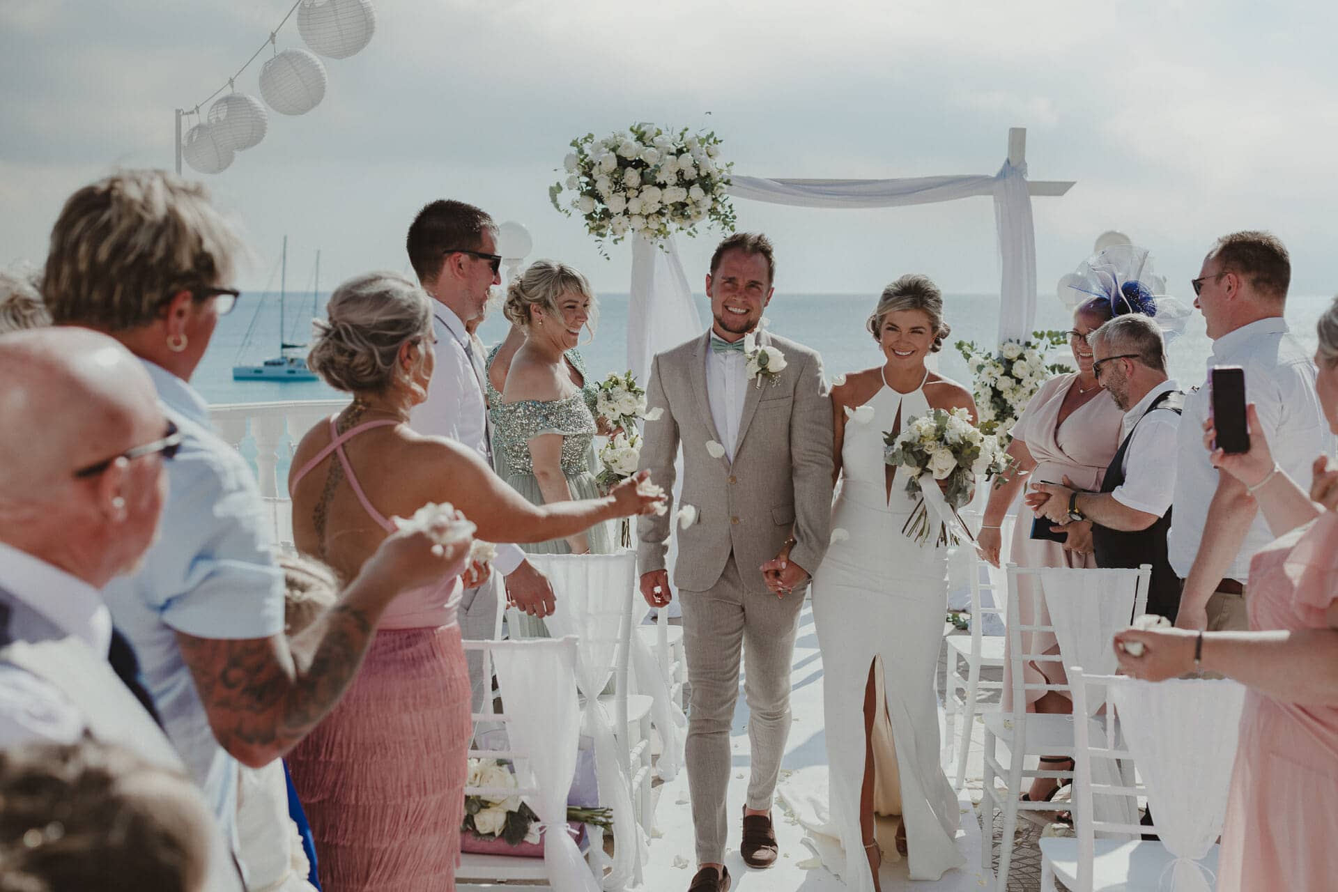 newlywed couple with photographer in ibiza walking from the altar