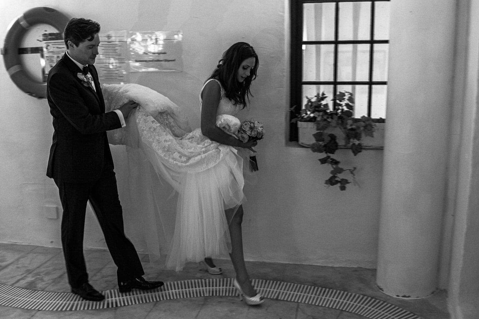 momento complicidad de pareja recien casada caminado en la piscina del hotel na xamena de ibiza.fotografia bea bermejo photographer ibiza 2020