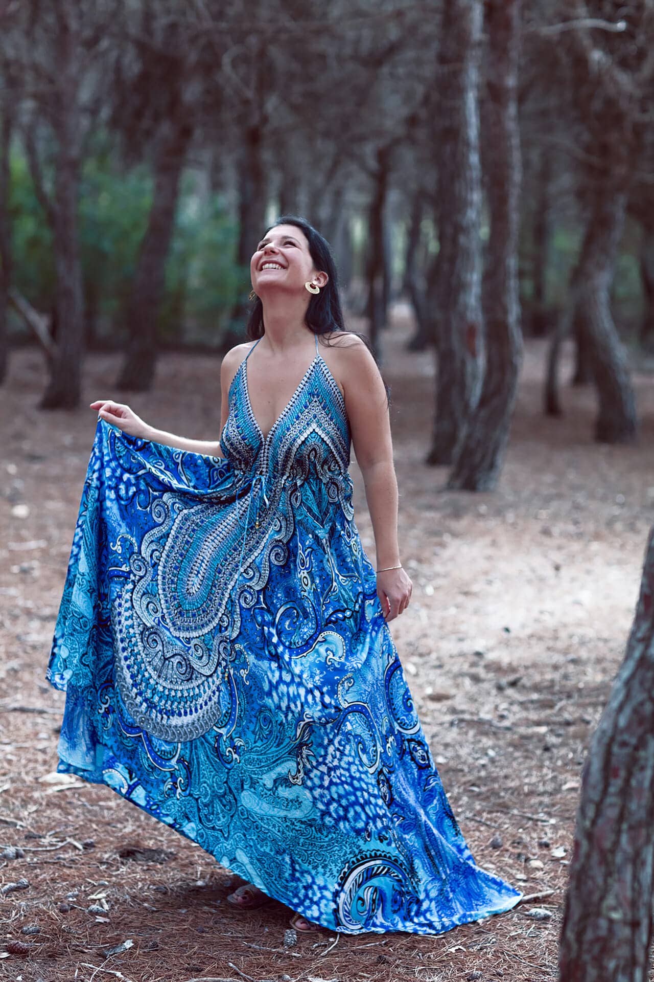 imagen de mujer jugando con vestido en bosque por fotografo en ibiza