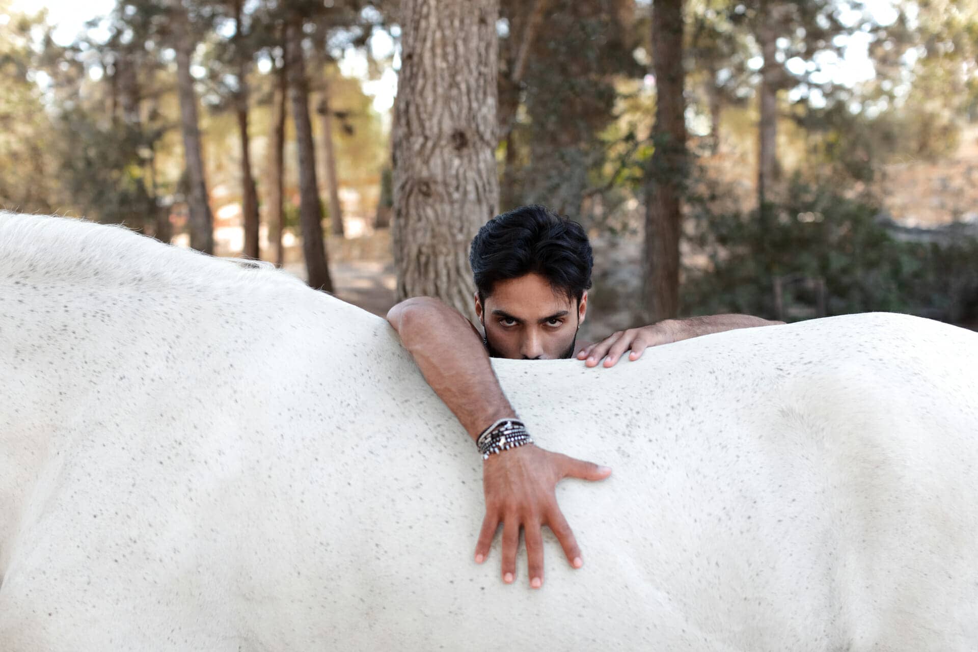 retrato de chico apoyado sobre lomo de caballo de fotografo en ibiza