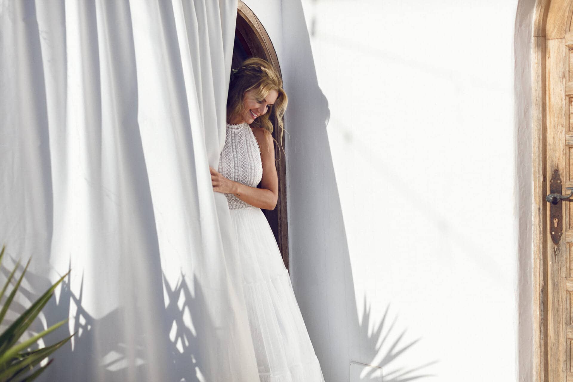 imagen de fotografo ibiza de novia timida junto a una cortina