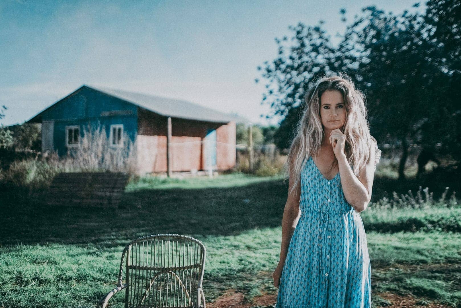 imagen de modelo posando al lado de una silla en el terreno de una casa de campo de ibiza