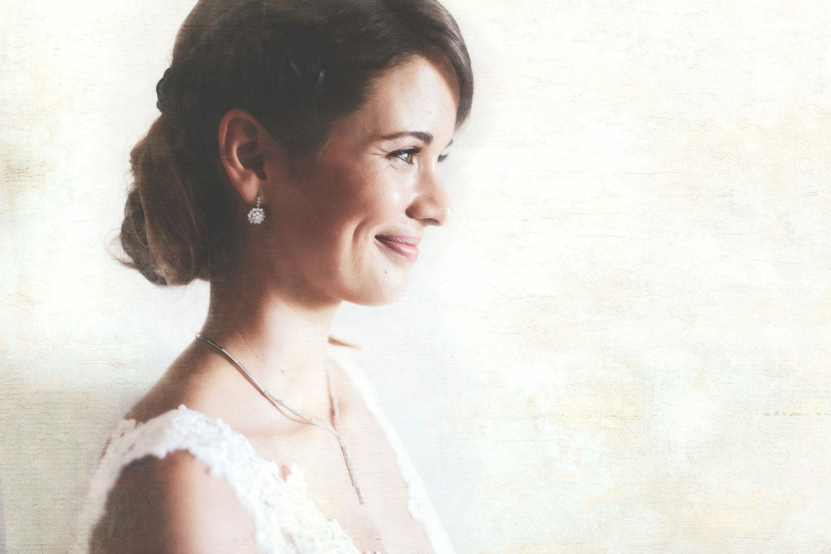 retrato fotografico lateral de novia sonriendo con fondo blanco en fotógrafo de boda en Ibiza