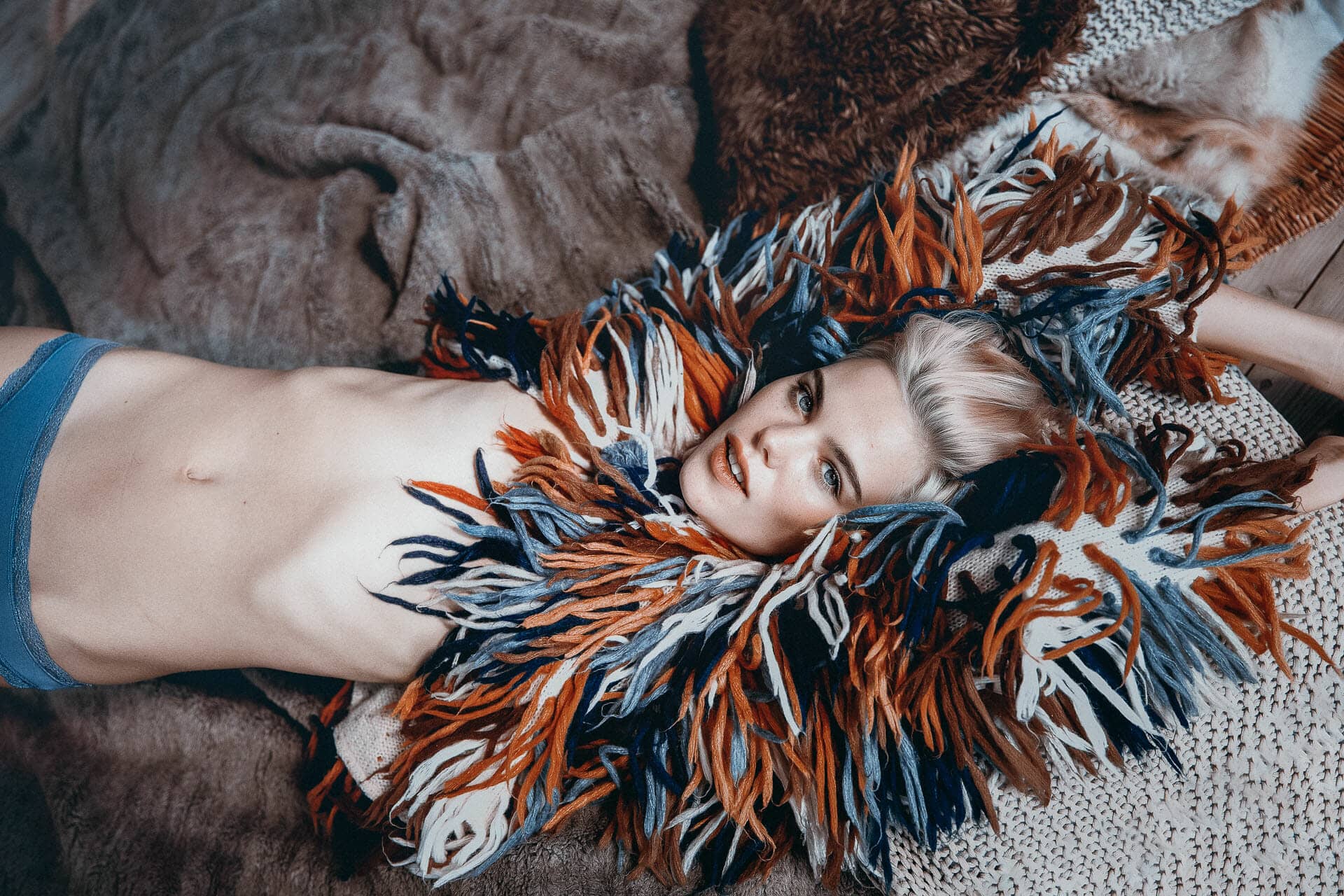 Posado fotografico publicitario con cheekfrills de braguitas con Julia Almendra tumbada sobre manta y vestida con jersey de pelos en casa de campo de Ibiza