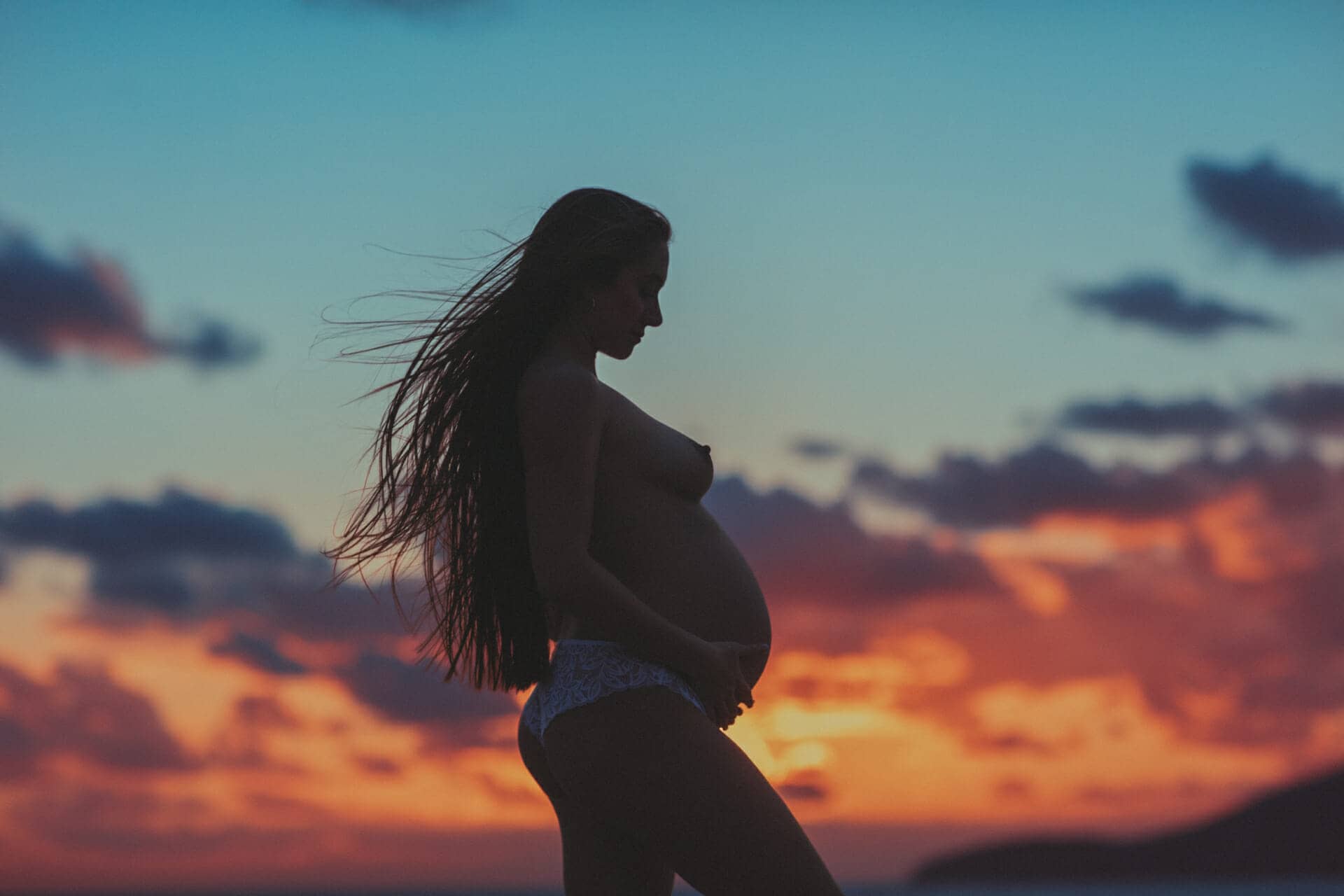 fotografia de joven embarazada en ibiza al atardecer y a contraluz