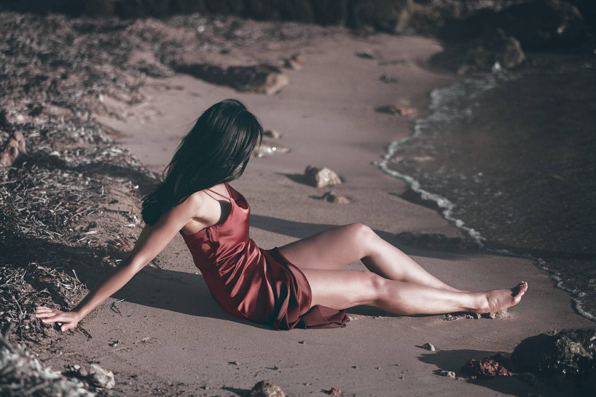 mujer sentada en orilla de playa de santa eulalia por photographer ibiza